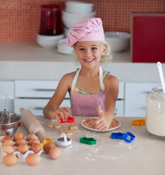 Schöne junge Mädchen bei der Arbeit in der Küche Daumen hoch — Stockfoto