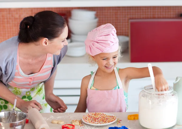 Glada lilla flickan bakning med hennes mor cookies — Stockfoto