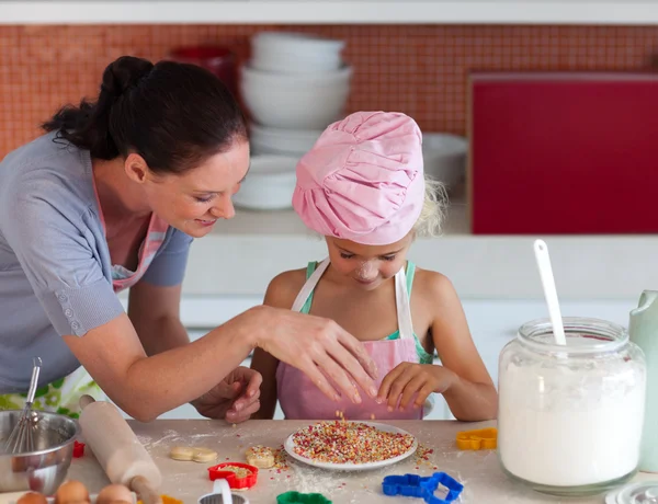 Young mother with her daughter baking — Stockfoto