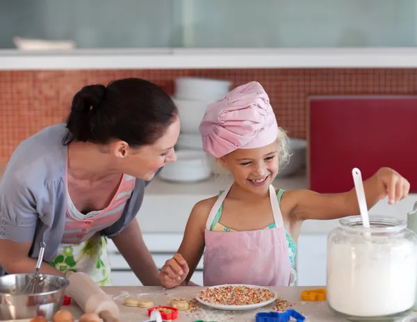 Mladá matka v kuchyni učí dítě — Stock fotografie