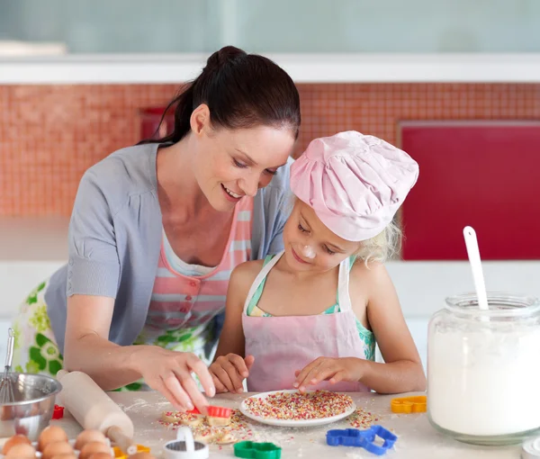 Sweet little girl showing her mother her cookies — Stock Photo, Image