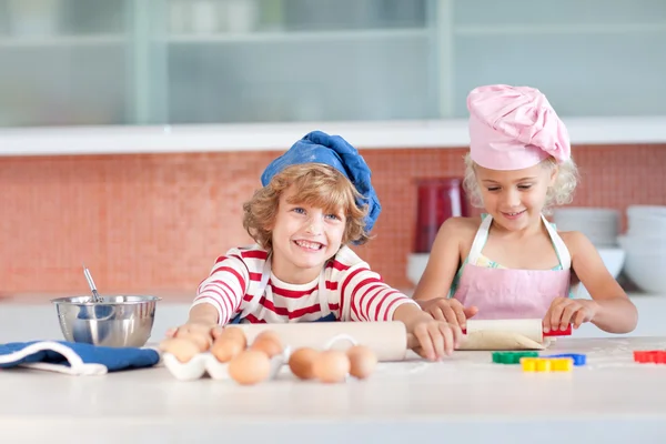 Jolly siblings cooking biscuits — Stock Photo, Image