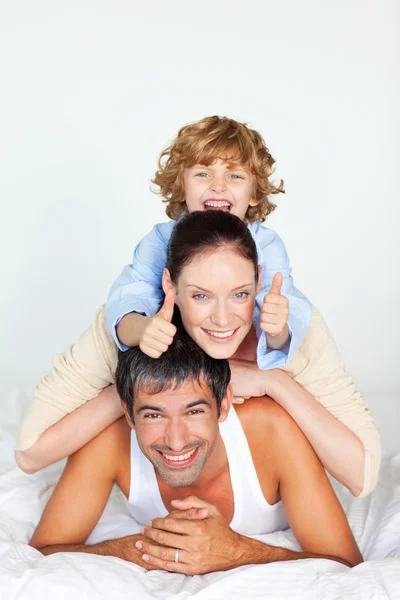 かわいい男の子の両親の背中に登る — ストック写真