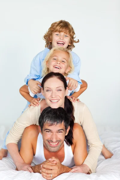 Parents and children playing together in bed — Stock Photo, Image