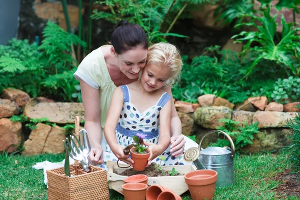 Aufmerksame Mutter mit ihrer süßen Tochter im Garten — Stockfoto