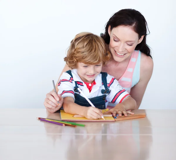 Brunette woman drawing with a cute boy — Stock Photo, Image