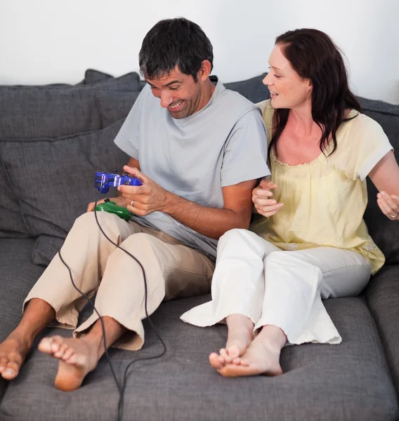 年轻夫妇玩视频游戏在沙发上 — 图库照片