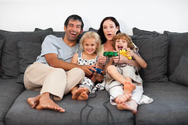 Веселая семья играет в видеоигры — стоковое фото