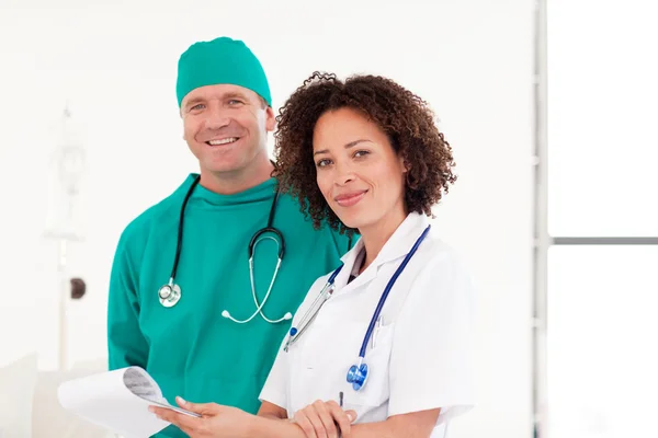 Chirurg en verpleegkundige glimlachen naar de camera — Stockfoto