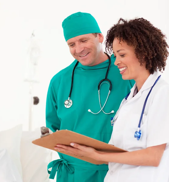 Bright medical team holding a clip board — Stock Photo, Image