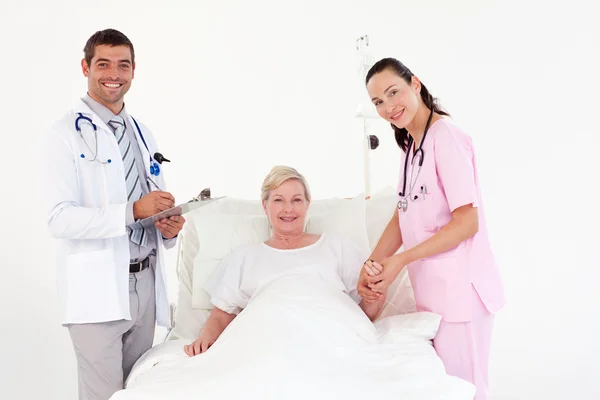 Vrouwelijke patiënt tussen verpleegster en arts — Stockfoto