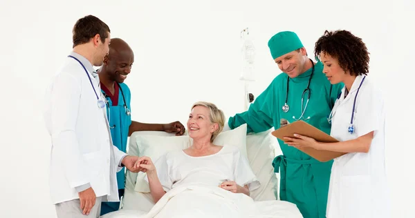 医生照顾一个生病的高级病人的团队 — 图库照片