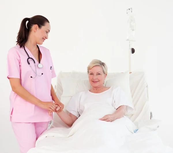 Vänlig sjuksköterska och leende kvinnlig patient — Stockfoto