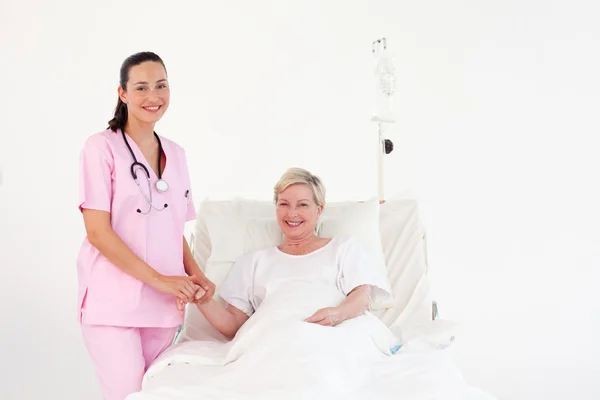 Smiling nurse in a hospital with a patient — Stock Photo, Image