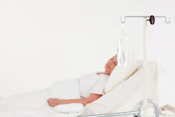 Mulher idosa deitada em uma cama de hospital — Fotografia de Stock