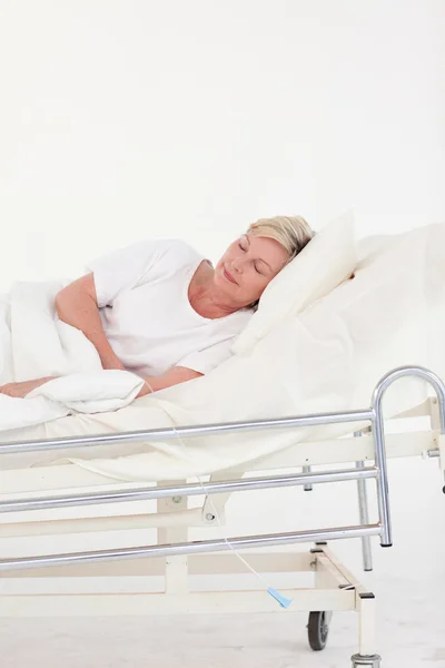 Stanca paziente anziana che dorme nel suo letto — Foto Stock
