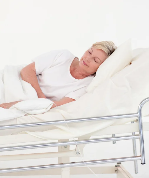 Elderly patient in white bed — Stock Photo, Image