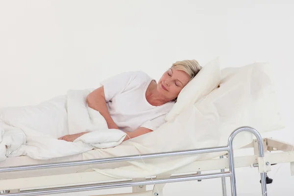 Chory starszy kobieta, leżąc na łóżku szpitalnym — Zdjęcie stockowe