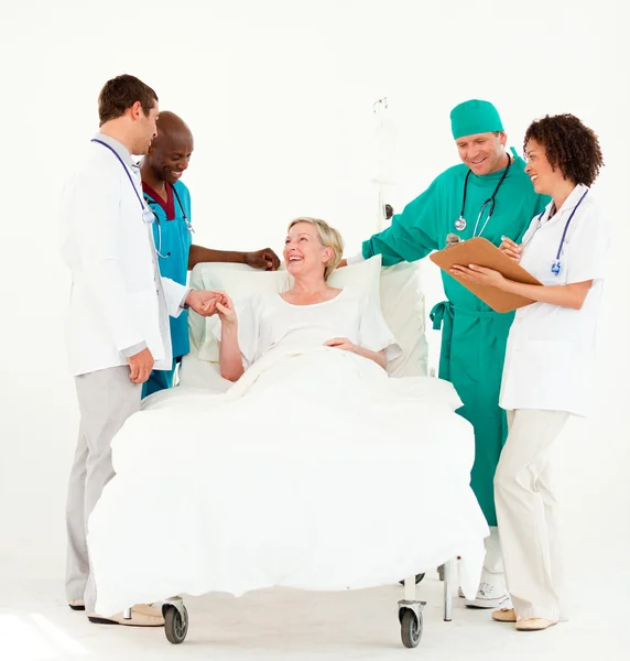 Cirurgião com médicos cuidando de um paciente sênior — Fotografia de Stock
