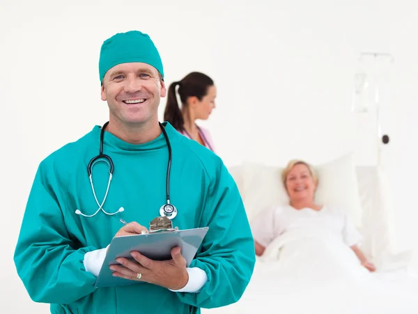 Przystojny chirurg uśmiechając się do kamery — Zdjęcie stockowe