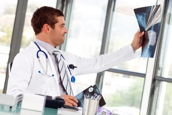 stock image Handsome doctor looking at a x-ray