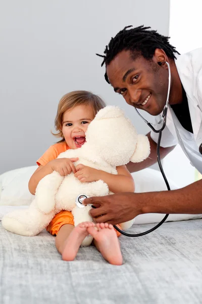 Cuidar médico examina uma menina bonito — Fotografia de Stock