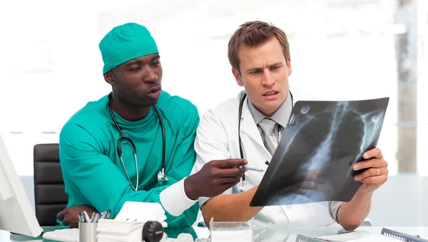 Молодой врач и хирург сосредоточены на рентгене — стоковое фото