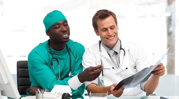Jovem médico e cirurgião olhando para um raio-x — Fotografia de Stock