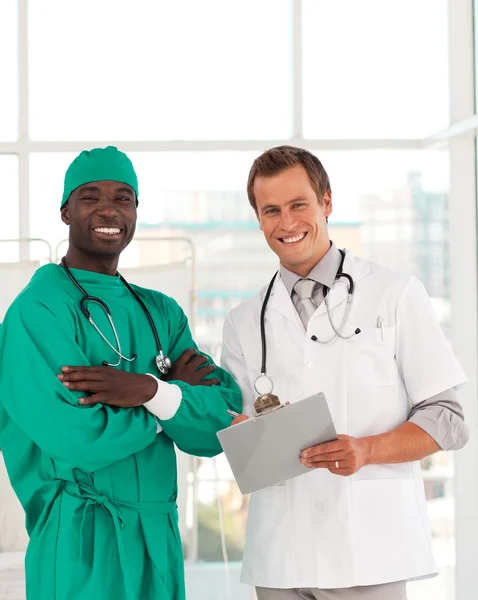 Хирург и доктор улыбаются в камеру — стоковое фото