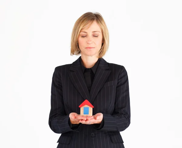 Smiling mature businesswoman holding a house — Stock Photo, Image