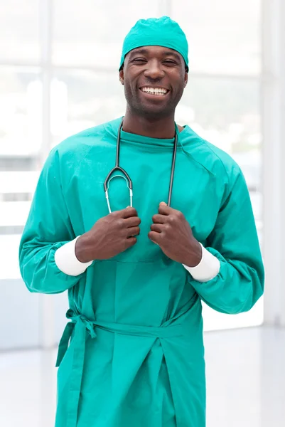 Jovem cirurgião sorrindo para a câmera segurando um estetoscópio — Fotografia de Stock