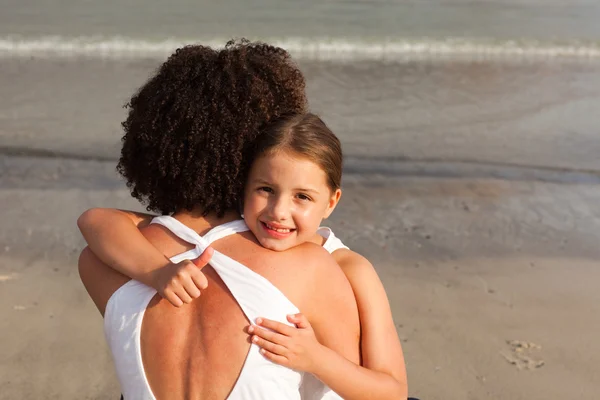 Ortræk af en smilende datter krammer sin mor - Stock-foto