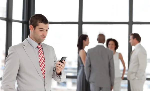 Usmíval se podnikatel drží telefon na pracovišti s jeho collea — Stock fotografie