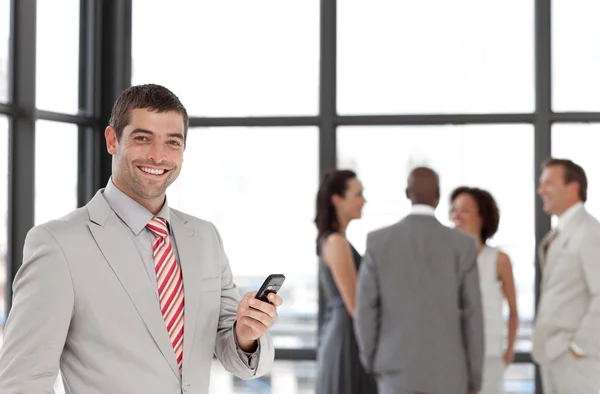 Hispanische Geschäftsmann hält ein Telefon am Arbeitsplatz mit seinem Colle — Stockfoto