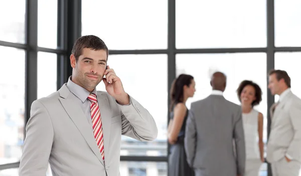 Серйозний бізнесмен тримає телефон на робочому місці зі своєю блошиною — стокове фото