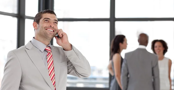 Молодой бизнесмен держит телефон на рабочем месте со своим коллегой — стоковое фото