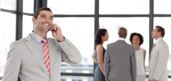 Dynamic businessman holding a phone at workplace with his collea — Stock fotografie