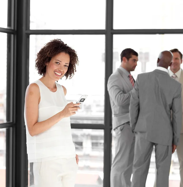 Cheerful Businesswoman holding a phone at workplace with his col — Stock Photo, Image