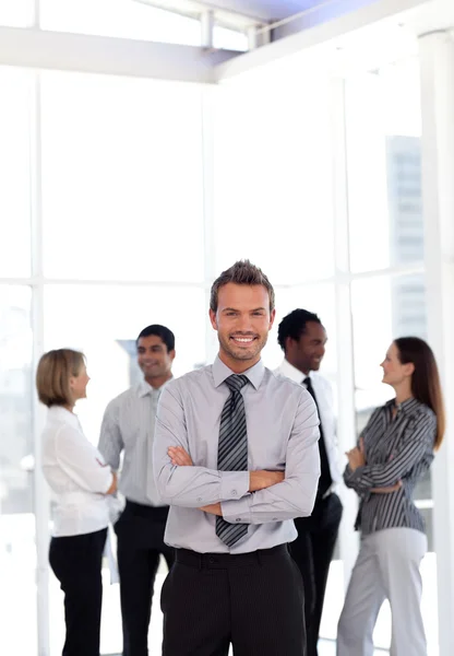 Charming business manager standing at the camera with his team — Stock Photo, Image