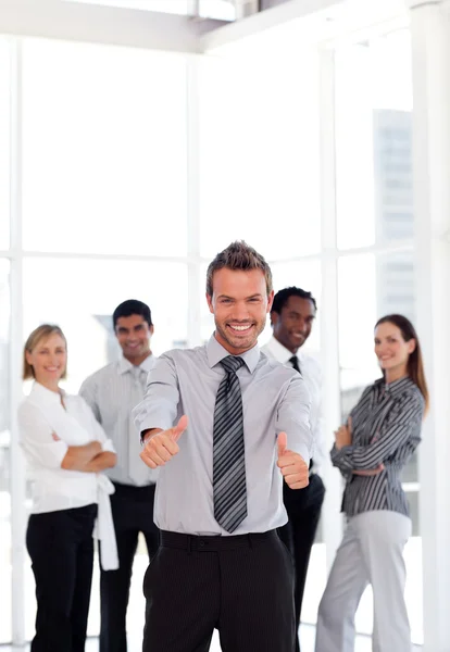 Positive business manager standing at the camera with his team — Stock Photo, Image