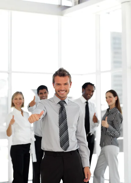 Уверенный бизнес-менеджер, стоящий перед камерой со своей командой — стоковое фото
