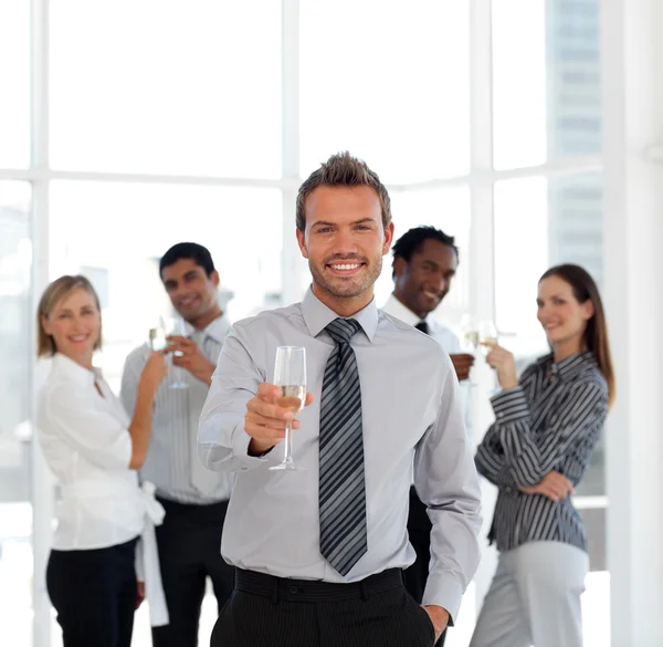 Улыбающийся бизнес-менеджер держит бокал со своей командой — стоковое фото