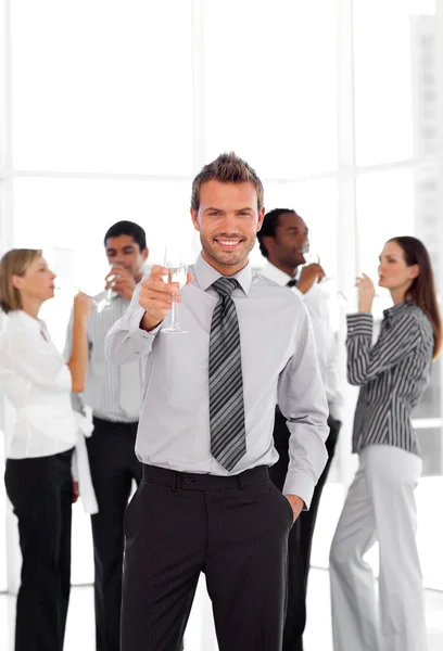 Joyful business manager holding a glass with his team — Stock Photo, Image