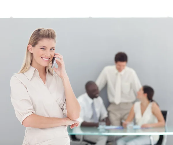Gelukkige vrouw praten over de telefoon met haar team — Stockfoto