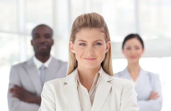 Self-assured businesswoman standing at the camera with arms fold — Stock Photo, Image