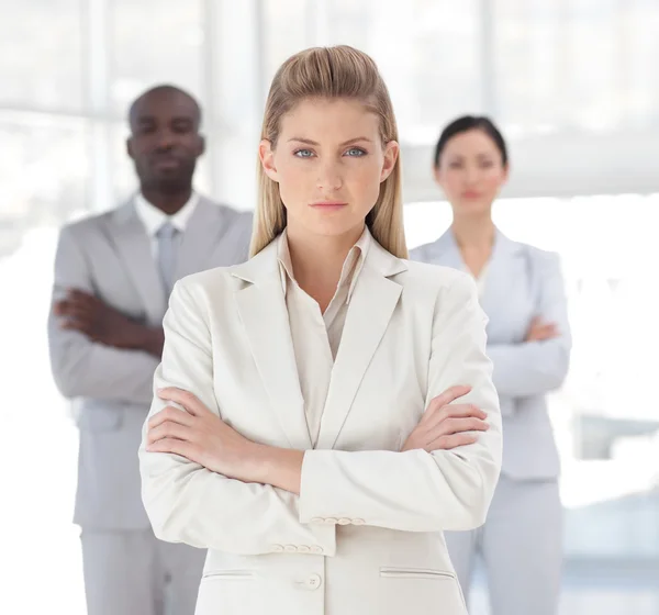 Charming businesswoman standing at the camera with arms folded — Stock Photo, Image