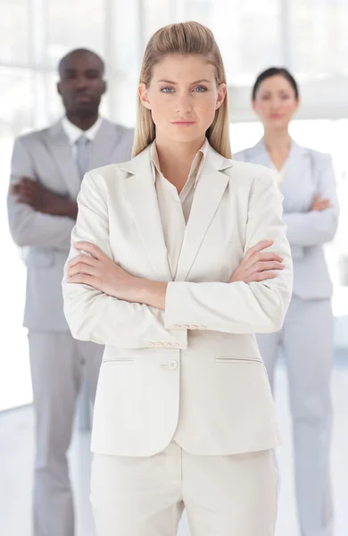 Delighted businesswoman standing at the camera with arms folded — Stock Photo, Image