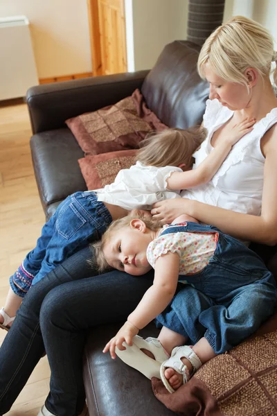 Sonriente chica acostada en el sofá con su madre —  Fotos de Stock