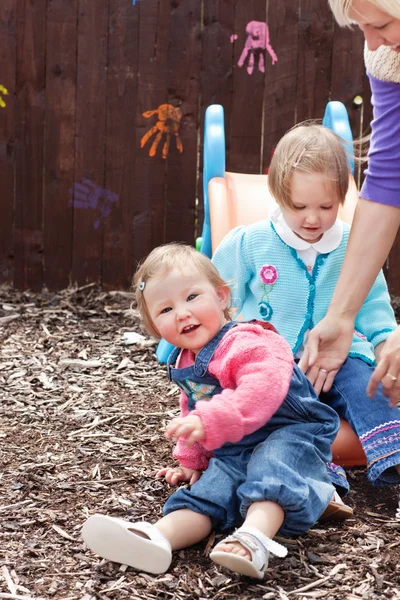Meninas pequenas e sua mãe se divertindo com um pára-quedas — Fotografia de Stock