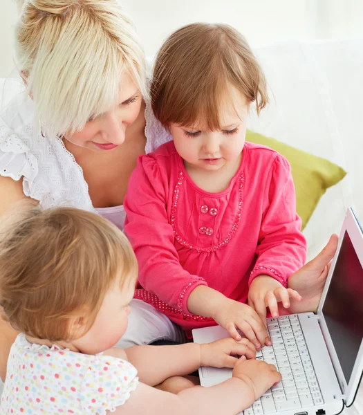 Família alegre se divertindo com um laptop na sala de estar — Fotografia de Stock